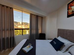 库斯科Hotel Qori Punku的酒店客房设有一张床和一个大窗户