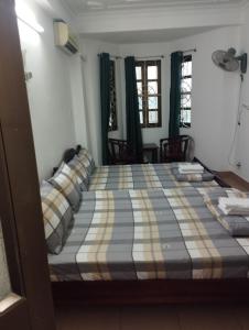 胡志明市Sứ Lạng Hotel的一间卧室配有一张带蓝白色毯子的床