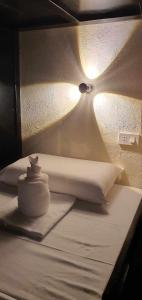 锡基霍尔泰格巴莱恩山林小屋旅馆的一张白色的床,上面有灯