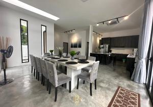 新山The Luxurious 27, Johor Bahru的一间配备有白色桌椅的用餐室