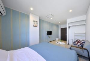 Kogushiseaside villa HILIFE - Vacation STAY 99018的一间带蓝色墙壁、一张床和电视的卧室