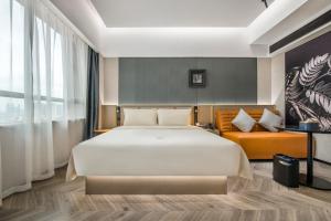 广州广州珠江太古仓亚朵S酒店的一间卧室配有一张大床和一张沙发