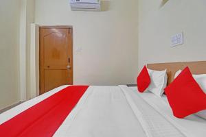 Haidar Sāhibgūda80983G RBS Square Langer Houz的一间卧室配有红色和白色枕头的床
