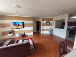 马查拉Departamentos de la Costa的客厅配有沙发和墙上的时钟