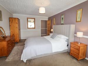 拉尔Beach Cottage的卧室配有白色大床和木制家具
