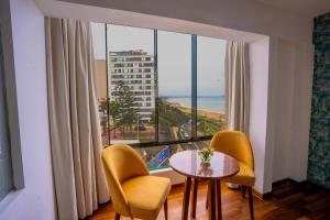 利马Golden Mar Hotel的客房设有桌椅和大窗户。