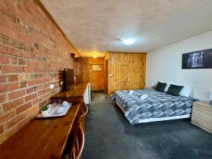 斯托尔钻石屋文化遗址餐厅及汽车旅馆的一间卧室设有一张床和砖墙