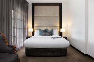 赫本温泉Mineral Springs Hotel Hepburn的卧室配有带蓝色枕头的大型白色床