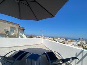 伊斯基亚La fortezza的阳台配有桌椅和遮阳伞