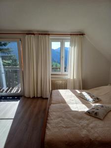 Ferienhaus Häusler的一间卧室设有一张床和一个大窗户