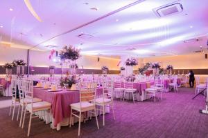 IliganGo Hotels Iligan的宴会厅配有桌椅和紫色的桌布