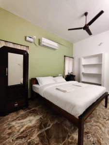 蓬蒂切里Maison Nataraja的一间卧室配有一张大床和吊扇