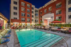 洛杉矶Charming Luxury Apartment with Hollywood Sign View的一座带椅子的酒店游泳池,一座建筑