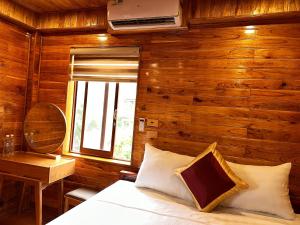 宁平Tam Coc Rocky Hotel的一间卧室配有一张床、一张书桌和一个窗户。