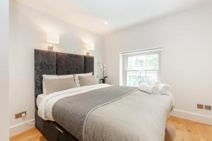 伦敦Central Fitzrovia - 1BR - CityApartmentStay的一间卧室配有一张大床和大床头板