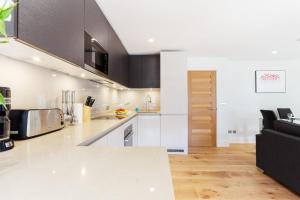 伦敦Central Fitzrovia - 1BR - CityApartmentStay的厨房配有白色台面和黑色沙发