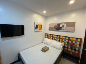 长滩岛Ati Lodge Boracay的一间小房间,配有沙发和平面电视