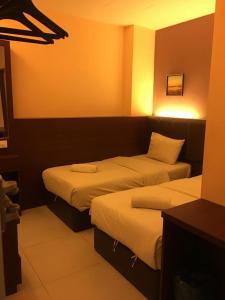马六甲AVARIA SIGNATURE的配有灯的酒店客房内的两张床