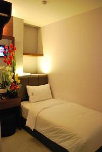 马六甲AVARIA SIGNATURE的配有一张床和花瓶的酒店客房