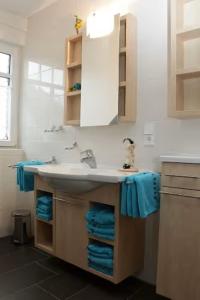 博尔库姆Ferienhaus Inselliebe的浴室配有水槽和蓝色毛巾