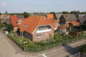 博尔库姆Ferienhaus Inselkate的郊区一座带橙色屋顶的房子