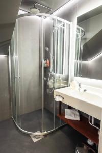 鲁卡皇家卢卡酒店的一个带水槽的玻璃淋浴间
