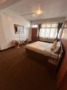 大吉岭The Valaya Hotel的一间卧室设有一张大床和一个窗户。