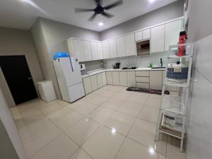 日得拉Ziyyad's Homestay的厨房配有白色橱柜和吊扇