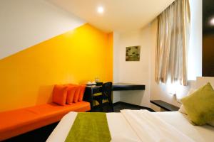 怡保Golden Roof Hotel Ampang Ipoh的配有一张床和一张书桌的酒店客房