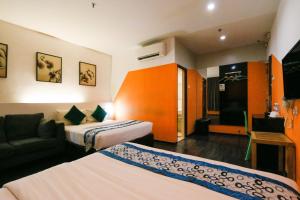 怡保Golden Roof Hotel Ampang Ipoh的酒店客房,设有两张床和一张沙发