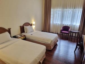 金马仑高原金马仑高原遗物酒店的酒店客房设有两张床和窗户。