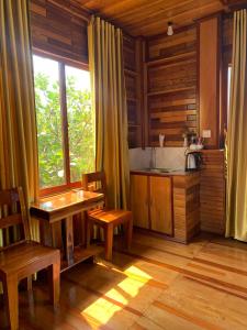 森莫诺隆Samnang Leap guesthouse的厨房配有桌椅和窗户。