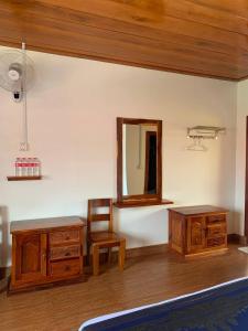 森莫诺隆Samnang Leap guesthouse的配有木制家具、镜子和椅子的客房