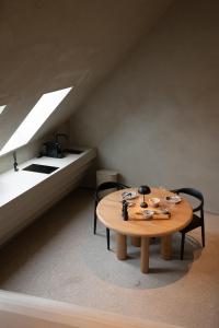 拉纳肯Luxe in Het Posthuis - nieuwe Stijlvolle Verblijven in Oud-Rekem的配有桌子和两把椅子及一张床的房间