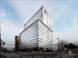 埼玉市Daiwa Roynet Hotel Omiya-nishiguchi的一座高大的白色建筑,有很多窗户