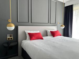 巴尼奥勒德日洛恩杜贝里水疗酒店的卧室配有白色床和2个红色枕头
