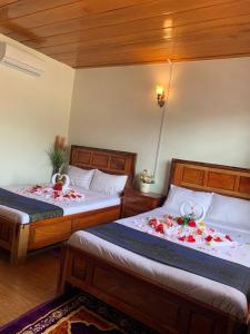 森莫诺隆Samnang Leap guesthouse的卧室内的两张带鲜花的床