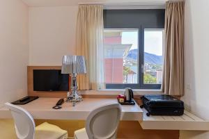 洛迦诺哈尼穆拉尔托酒店的客房设有书桌、电脑和窗户