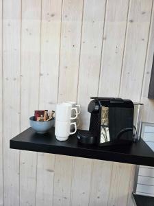 特罗姆瑟特罗姆瑟小屋露营地的一个带咖啡机和微波炉的黑架子