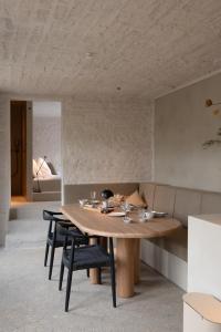 拉纳肯Luxe in Het Posthuis - nieuwe Stijlvolle Verblijven in Oud-Rekem的一间带木桌和椅子的用餐室