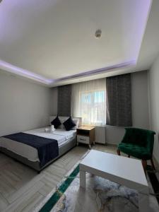 乔尔卢Luu Hotel的一间卧室配有一张床和一把绿色椅子