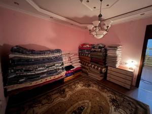 CoratEden Guest House的一间房间,配有一堆衣服和吊灯