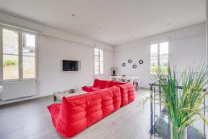 波尔多L'Arcachonnaise by Cocoonr的客厅配有红色沙发和电视