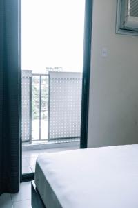 宿务蔡酒店及公寓的一间卧室设有一张床和一个大窗户