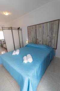 波尔蒂芒Urban Beach - A Casa dos Sonhos的一张蓝色的床,上面有两个白色枕头