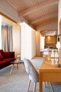 加姆利茨温兰德霍夫酒店的客厅配有桌子和红色沙发