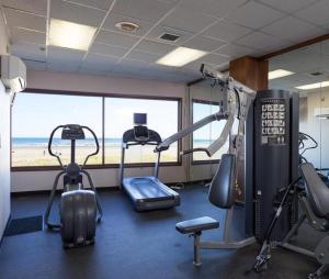 西塞德Promenade Inn & Suites Oceanfront的配有有氧器材的健身房,享有海滩美景