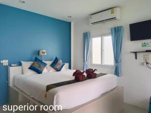 拉迈普汉纳度假村的卧室配有白色大床和蓝色的墙壁