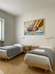 维罗纳Palazzo Antoniazzi的墙上画画的房间里设有两张床