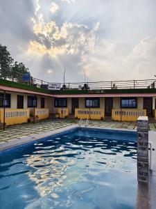马哈巴莱斯赫瓦尔Shayadri Farmhouse的一座建筑前面设有游泳池